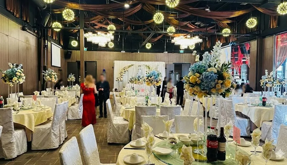 Salle de Pointe-Claire dressée pour un mariage — arches fleuries, plafonds hauts et tables rondes