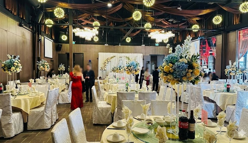 Salle de Pointe-Claire dressée pour un mariage — arches fleuries, plafonds hauts et tables rondes